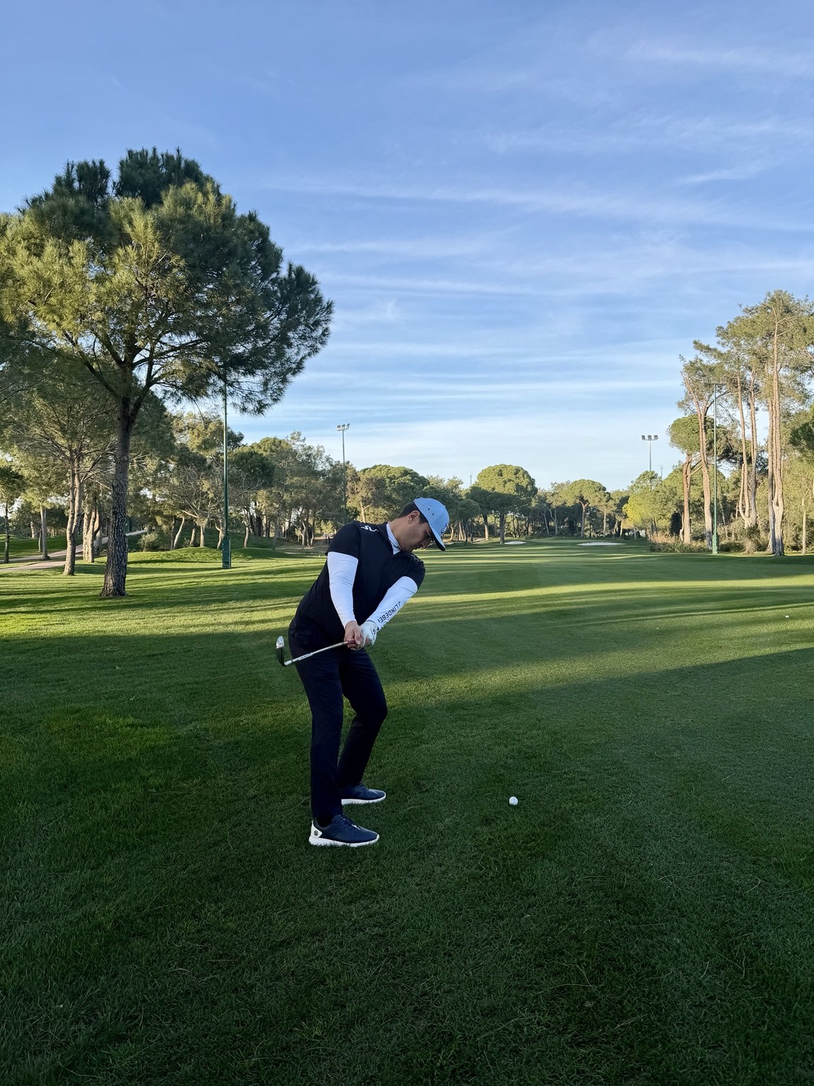 Golfer playing an iron shot on a fairway